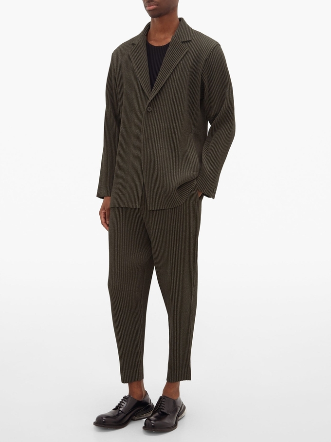 Bộ suit Homme Plissé Issey Miyake ứng dụng kỹ thuật ép nhiệt tạo nếp của Nhật Bản. Nhà sản xuất dùng vải tech mỏng cho cảm giác nhẹ, linh hoạt khi mặc. Áo có một hàng khuy, phần ve chữ V và tay áo kiểu button cuff, giá 594 USD (13,9 triệu). Quần xếp ly 310 USD (gần 7,3 triệu).